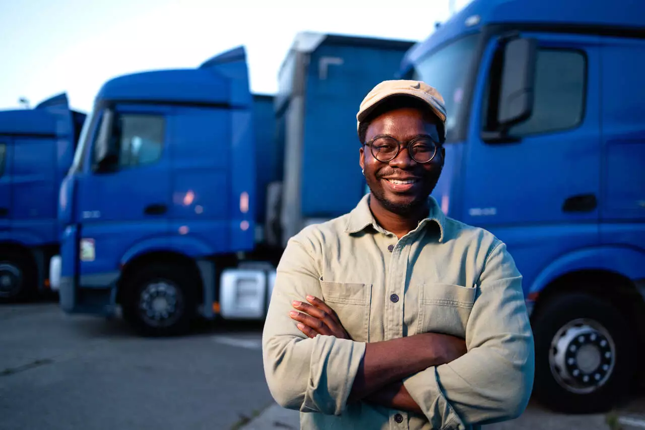 Motorista de caminhão sorrindo fazendo gestão de pátio