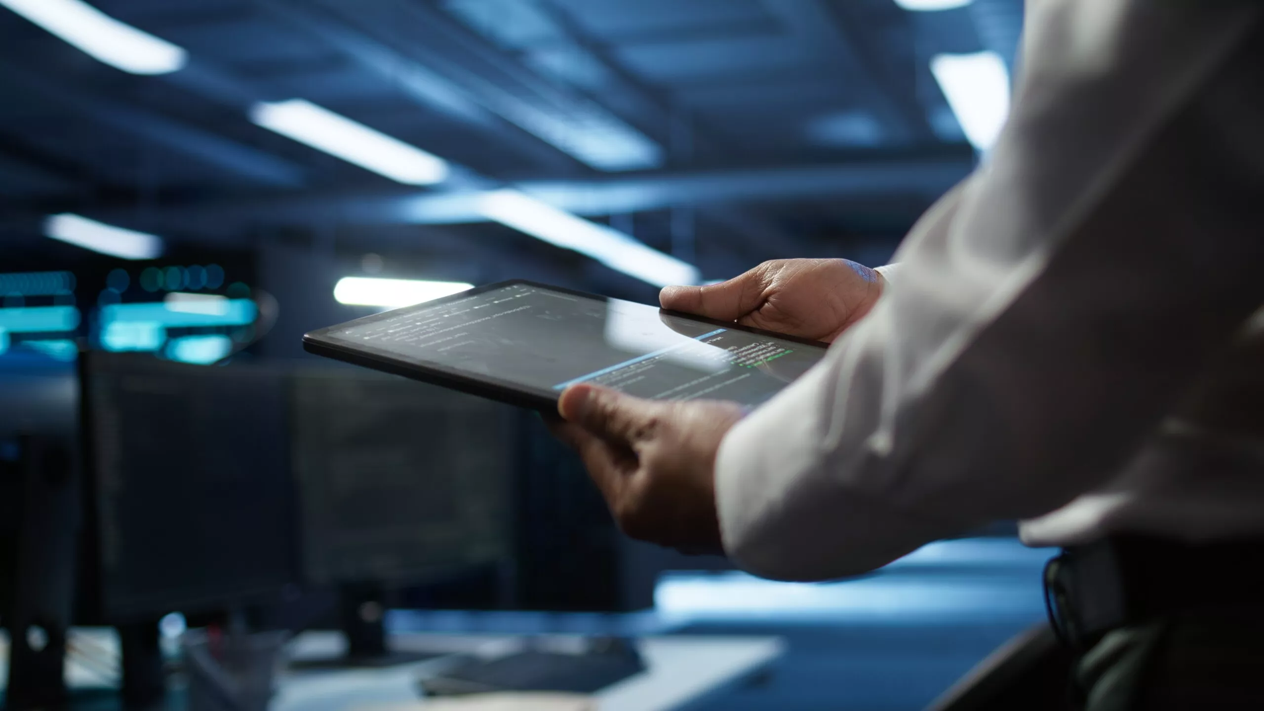 Close up of tablet used by IT worker doing maintenance on server farm gear